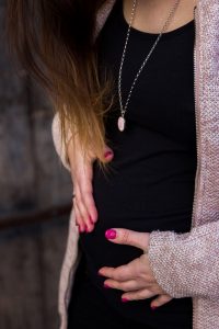 zwei Hände auf dem Babybauch - zweite Schwangerschaft