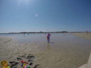 Kleinkind läuft im Sand am Strand Richtung Meer - Strandurlaub in Kroatien mit Kleinkind - Ninska Laguna Beach