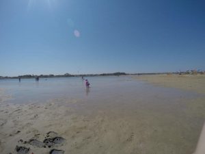 Mädchen läuft im Sand ans Meer, weiter Sandstrand un dflaches Wasser - der perfekte Kinder Strand in Kroatien in Nin - Ninska Laguna