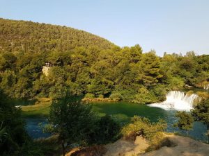 Grüne Wälder und Felslandschaft mit türkisblauem Seewasser in der Mitte - der KRka Nationalpark als Badeort im Kroatien bei unserem Strandurlaub in Kroatien mit Kleinkind