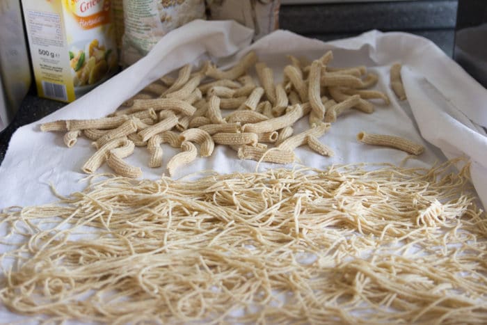 selbstgemachte Nudeln auf einem weißen Leinentuch- Pennen und Spaghetti aus Mehl und Grieß - ein tolles BLW Rezept für Babys und Kleinkinder