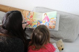 Mama und Tochter lesen "Wir sind jetzt vier" - ein Buch über Schwangerschaft und Geschwister Kinder im neuen großen Familienbett - bedürfnisorientiertes Familienleben