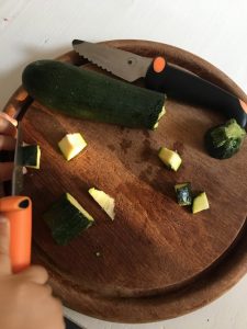 Zucchini werden geschnitten mit dem Kindermesser. Messer für Kinder sind ab etwa 2 Jahren super geeignet. Wir zeigen dir, welches Messer meine Tochter gerne benutzt um ihr Gemüse uns Obst selber zu schneiden. Die Feinmotorik wird traineirt und Verantwortung übernommen